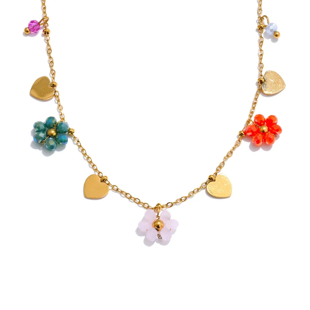 Gold necklace with colorful crystal flower and heart charms, part of 2026's flower jewelry trend.