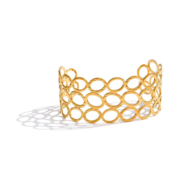Gold-plated bracelet with intricate circular design.