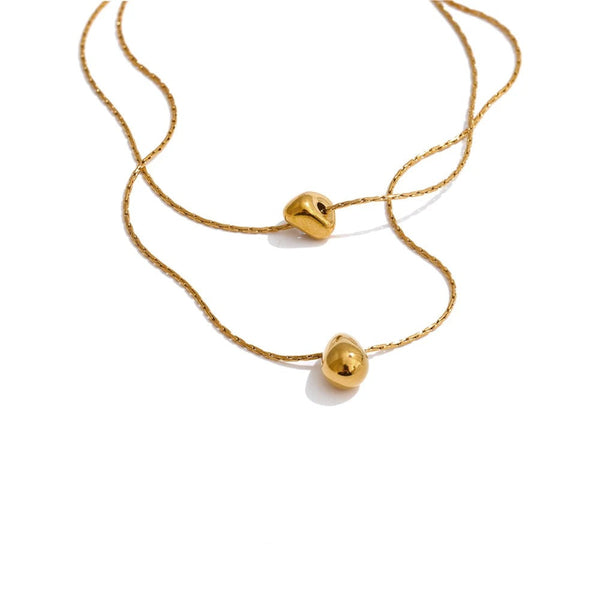 Gold-plated stainless steel necklace with a small ball pendant.