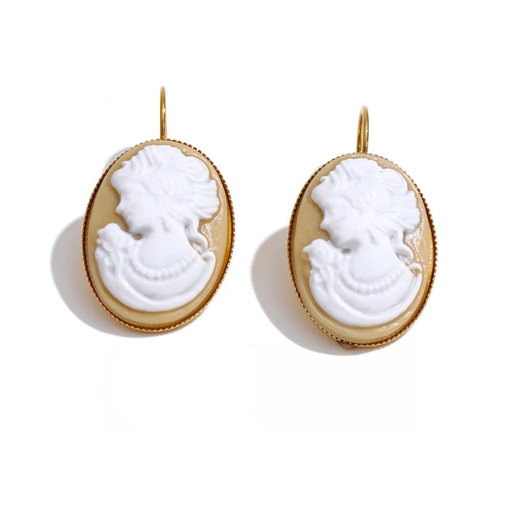 Earrings made of gold-plated stainless steel with resin, featuring a portrait of a woman in a white oval pendant.