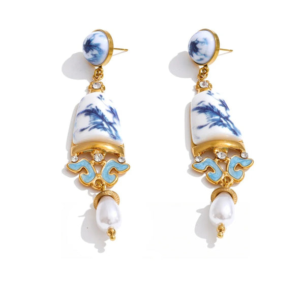 Gold-plated stainless steel earrings with pearl and resin detailing a blue and white pattern.