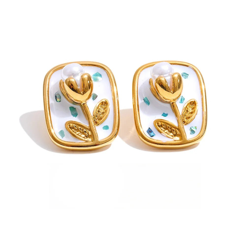 Gold-plated stainless steel earrings with pearl and enamel detailing a flower.