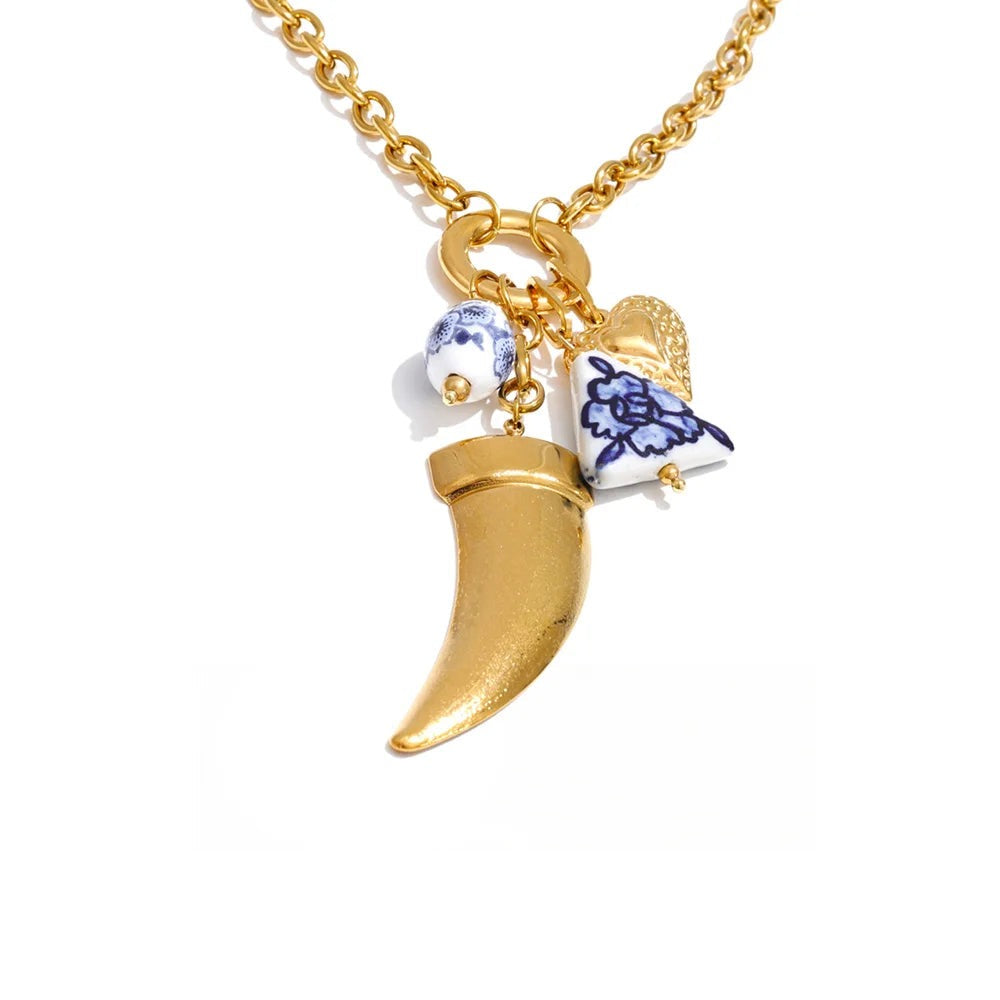 Gold-plated stainless steel necklace featuring a blue and white porcelain charm in the shape of a shoe, a gold-plated charm shaped like a unicorn horn, and a sm