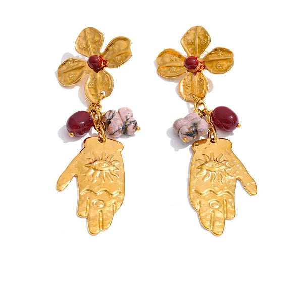 Gold-plated stainless steel earrings featuring a hand design with red stones and a sun motif.