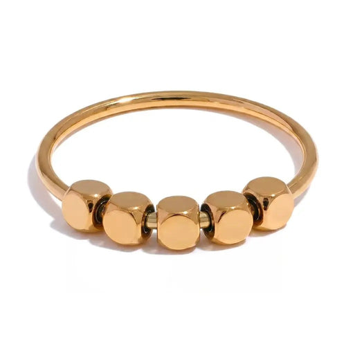 Gold-plated stainless steel ring with multiple small spheres on a white background.