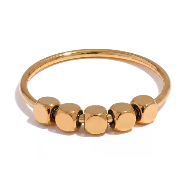 Gold-plated stainless steel ring with multiple small spheres on a white background.