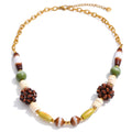 Gold-plated stainless steel necklace with beads in shades of brown and green.