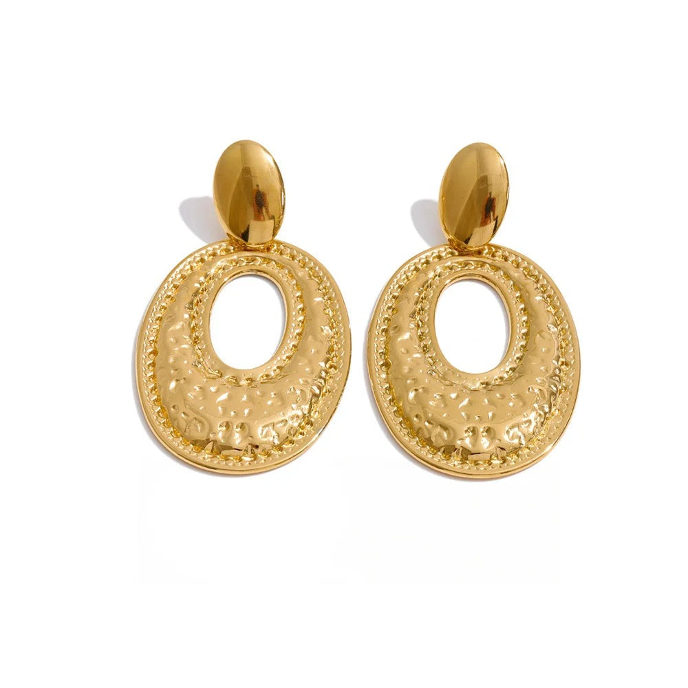 Gold-plated stainless steel earrings with a large circular design on each hoop.