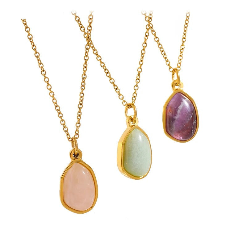 Gold necklace with three stone pendants in various colors.