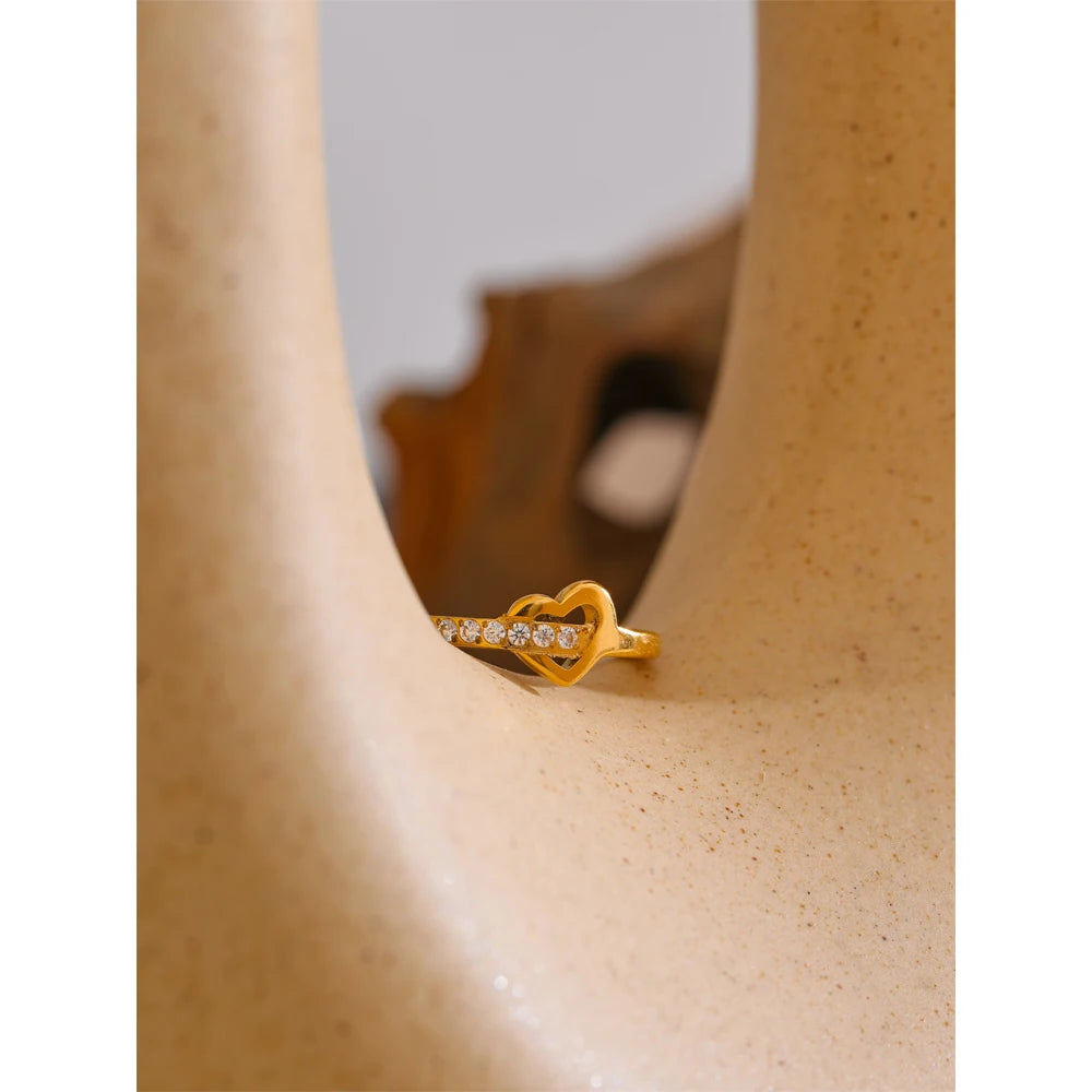 Cubic zirconia heart cross ring in 18K gold-plated stainless steel with cubic zirconia.
