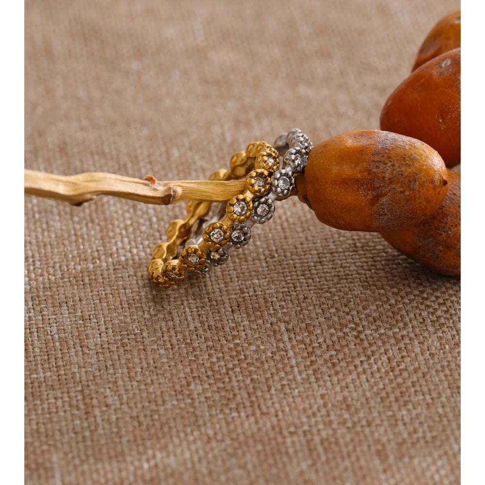 Cubic zirconia flower geometric ring in 18K gold-plated stainless steel with cubic zirconia.