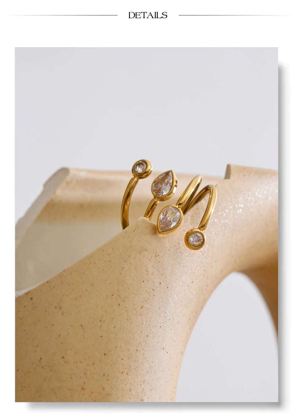 Cubic zirconia geometric layered ring in 18K gold-plated stainless steel with cubic zirconia.