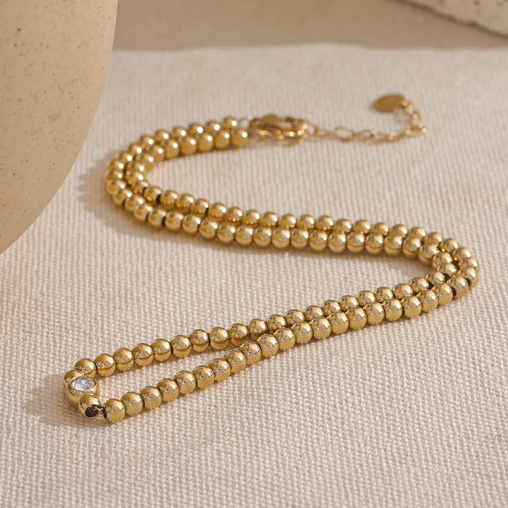 Cubic zirconia beaded geometric necklace in 18K gold-plated stainless steel with cubic zirconia.