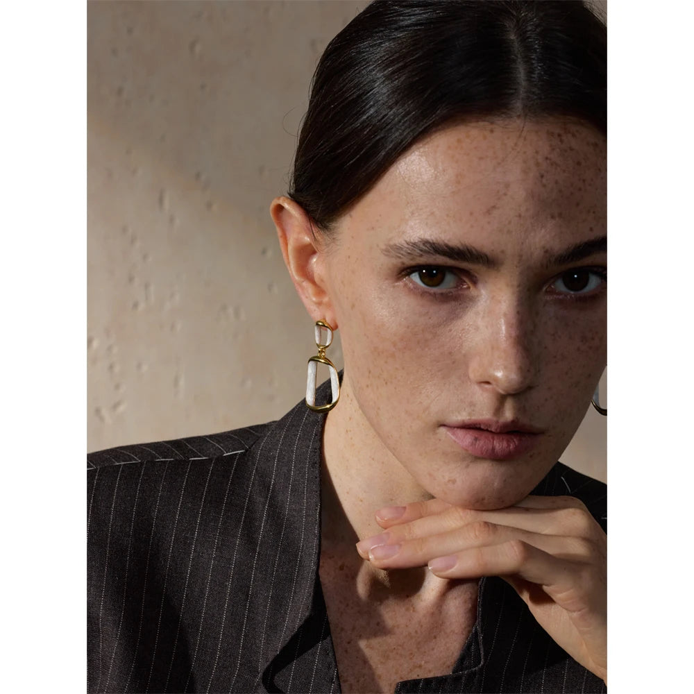White enamel geometric earrings in gold-plated stainless steel with enamel.