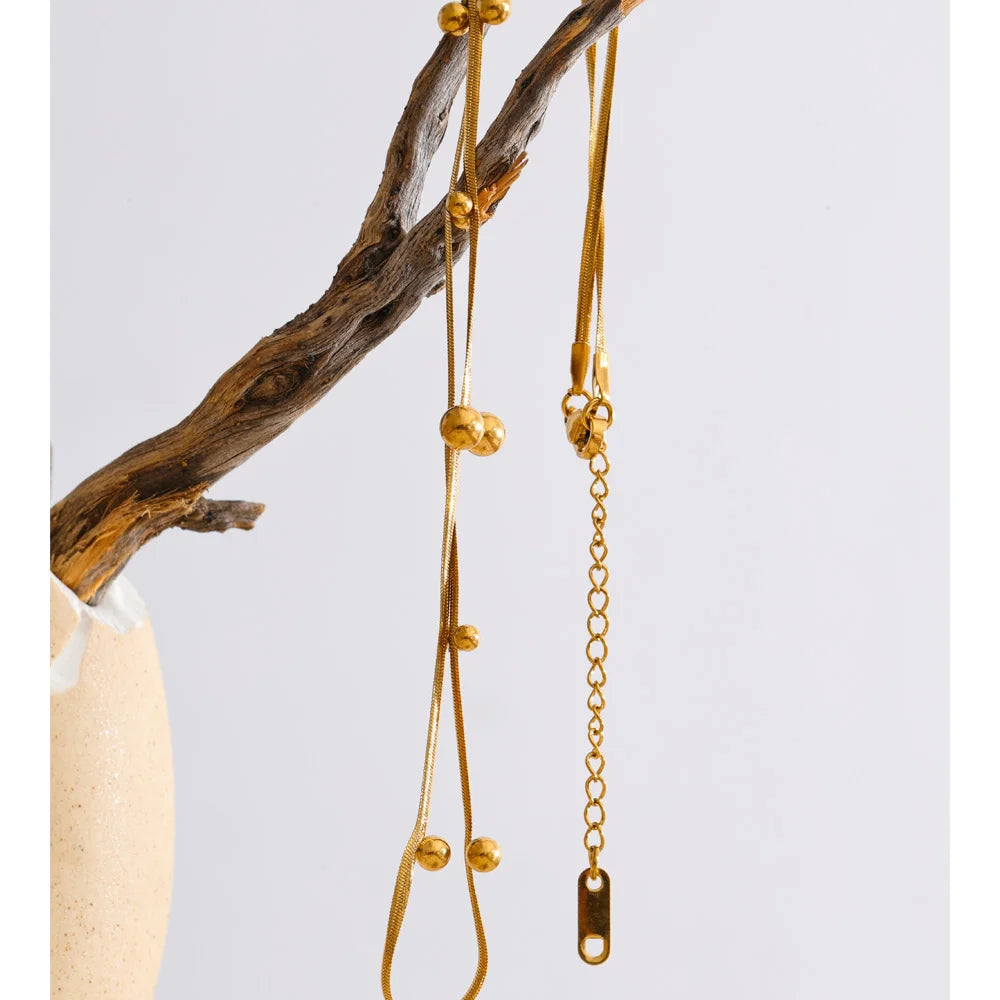Beaded geometric chain necklace in gold-plated stainless steel.