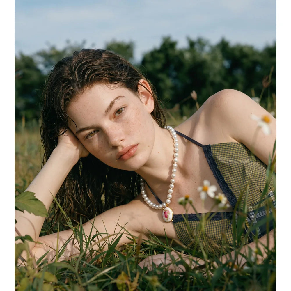 Pearl resin flower necklace in gold-plated stainless steel with pearl and resin.