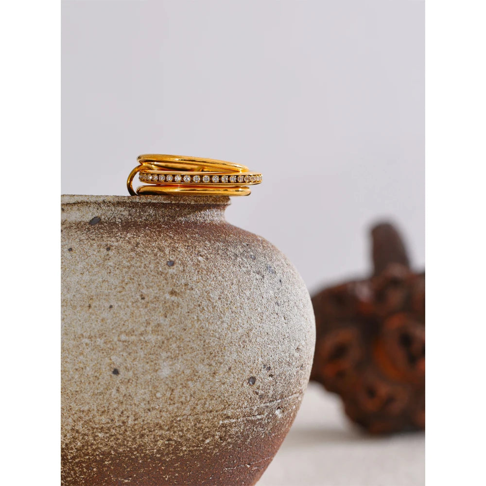 Cubic zirconia geometric layered ring in 18K gold-plated stainless steel with cubic zirconia.