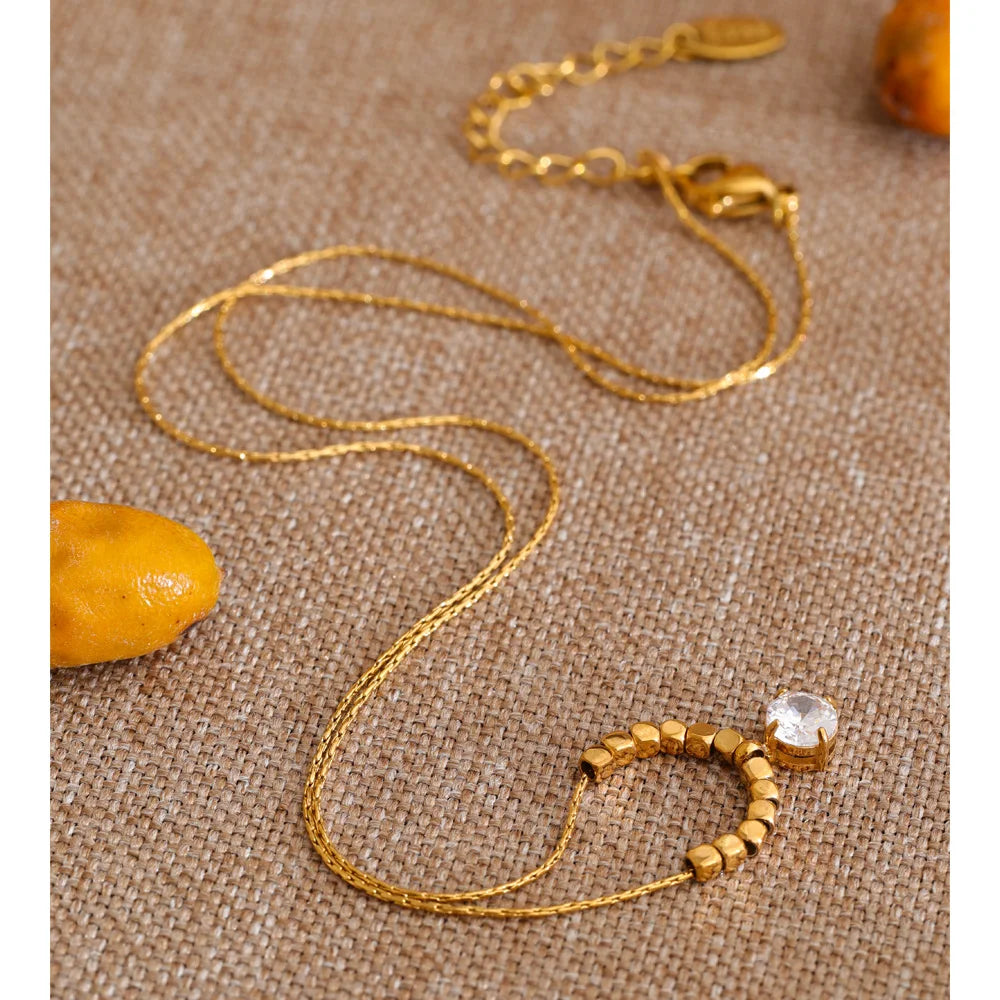 Cubic zirconia beaded geometric necklace in gold-plated stainless steel with cubic zirconia.