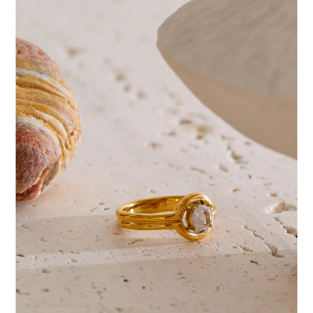 Cubic zirconia geometric ring in 18K gold-plated stainless steel with cubic zirconia.