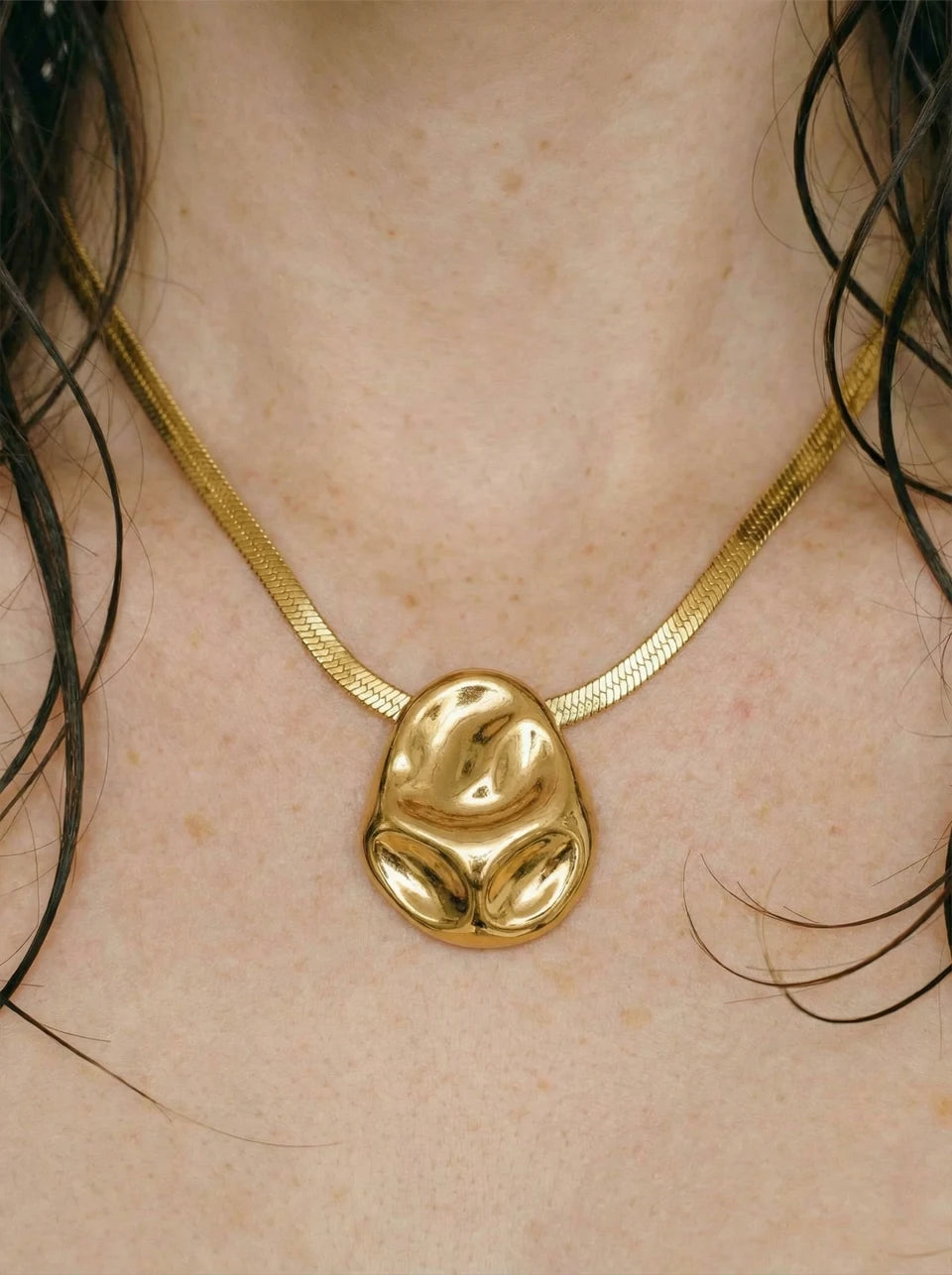 Hammered geometric necklace in gold-plated stainless steel.