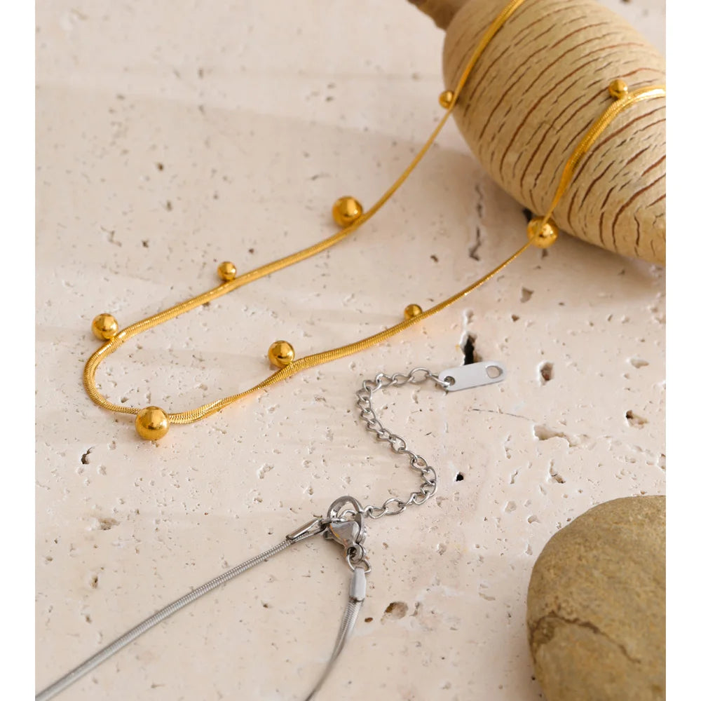 Beaded geometric chain necklace in gold-plated stainless steel.