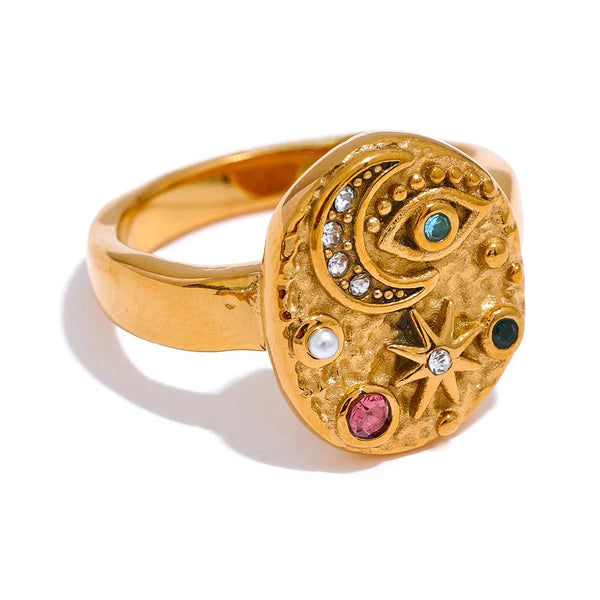 Gold-plated ring with a celestial design featuring stars and moons, set against a white background.