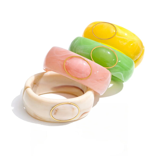 Three bracelets in a row, each with a different colored resin bead.