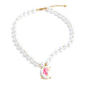 Pearl resin flower necklace in gold-plated stainless steel with pearl and resin.