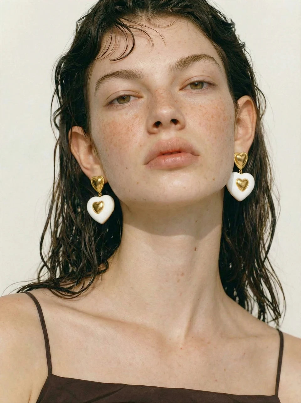 White enamel heart earrings in gold-plated stainless steel with enamel.