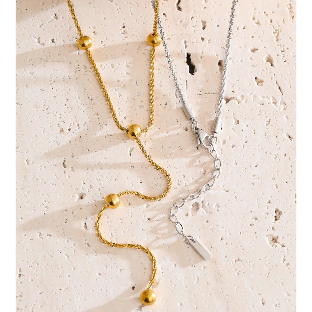 Beaded geometric chain necklace in gold-plated stainless steel.