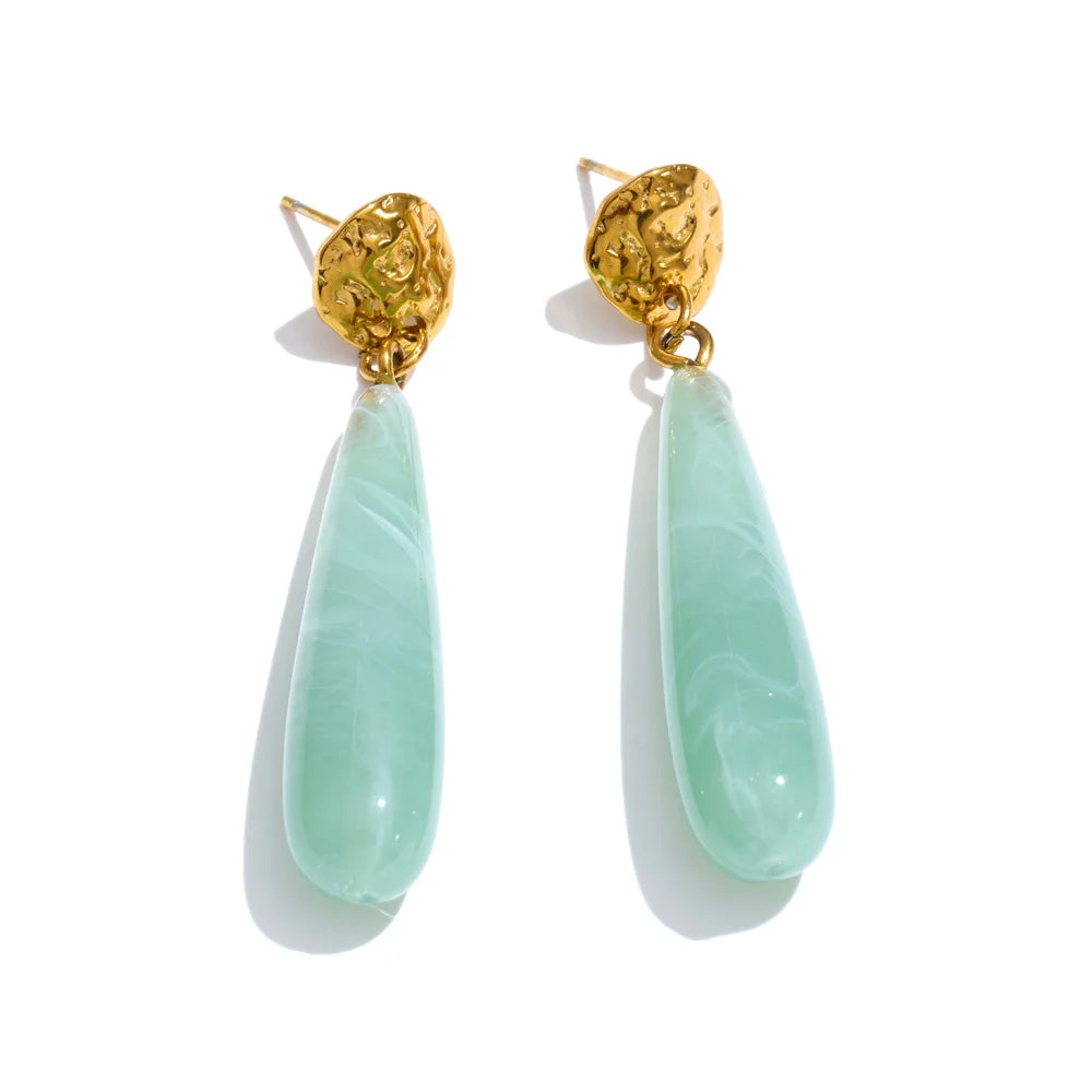 Gold-plated stainless steel earrings with resin, featuring a light blue stone and a teardrop shape.