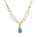 Gold-plated necklace with blue stone pendant.