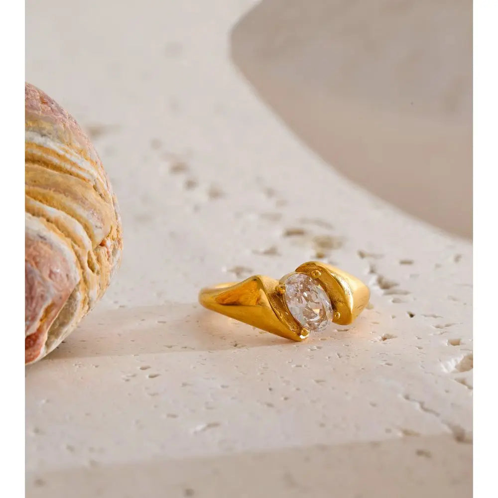 Cubic zirconia geometric ring in 18K gold-plated stainless steel with cubic zirconia.