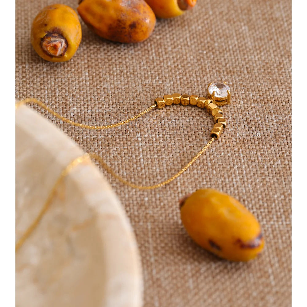 Cubic zirconia beaded geometric necklace in gold-plated stainless steel with cubic zirconia.