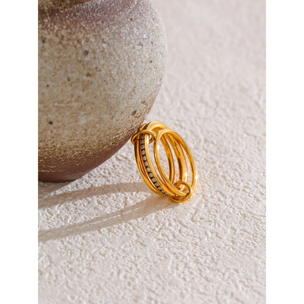 Cubic zirconia geometric layered ring in 18K gold-plated stainless steel with cubic zirconia.