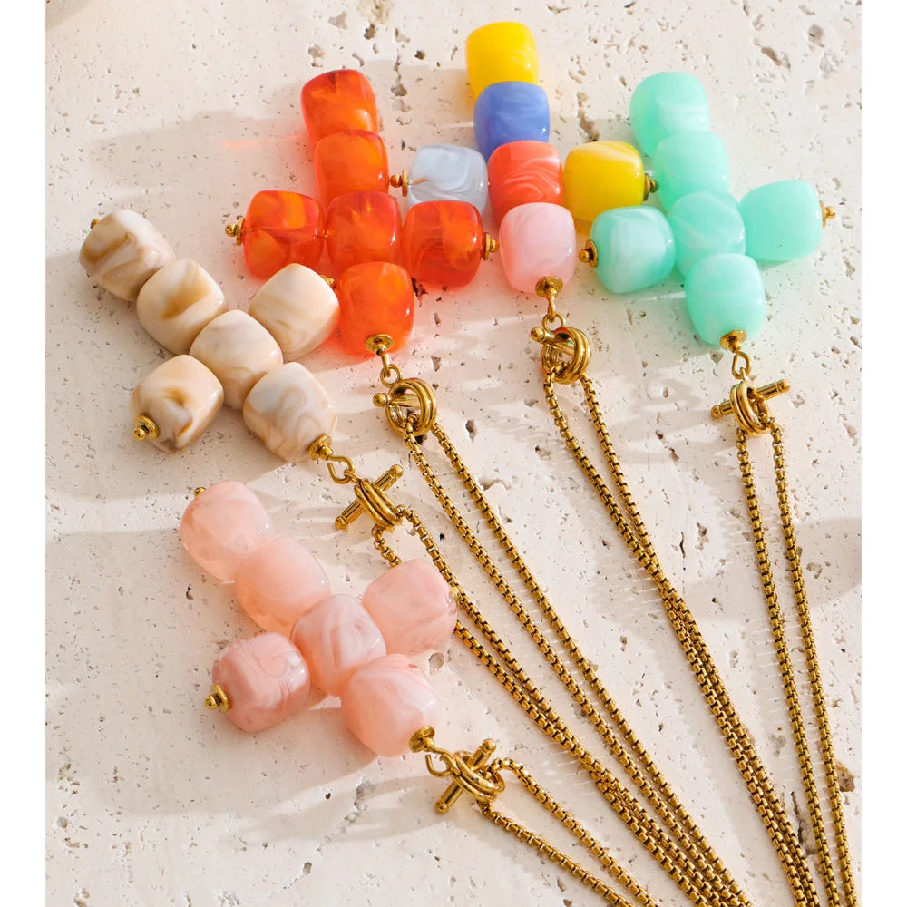 Resin acrylic cross necklace in gold-plated stainless steel with resin and acrylic.