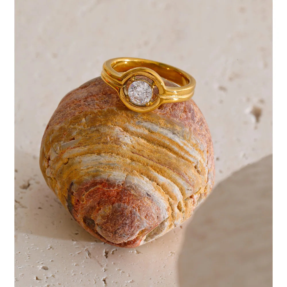 Cubic zirconia geometric ring in 18K gold-plated stainless steel with cubic zirconia.