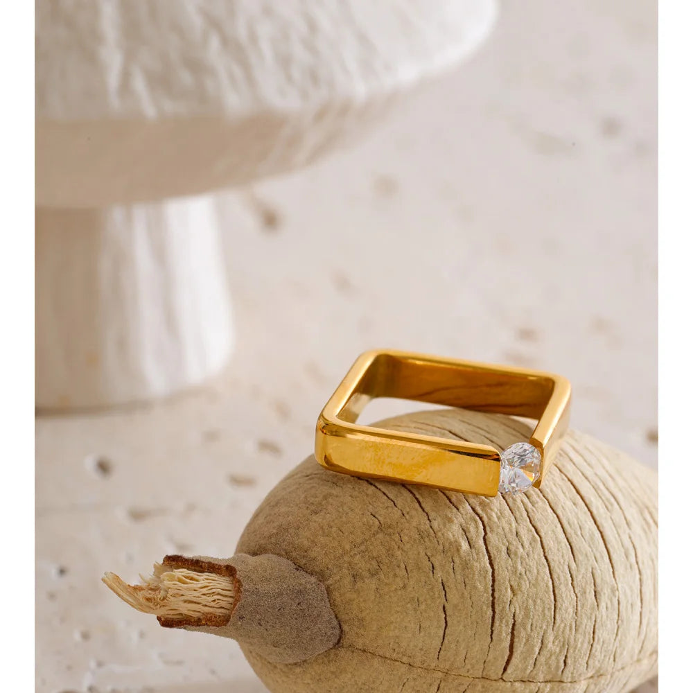 Cubic zirconia minimalist geometric ring in 18K gold-plated stainless steel with cubic zirconia.