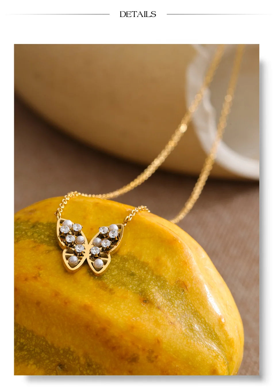 Cubic zirconia pearl butterfly necklace in gold-plated stainless steel with pearl and cubic zirconia.
