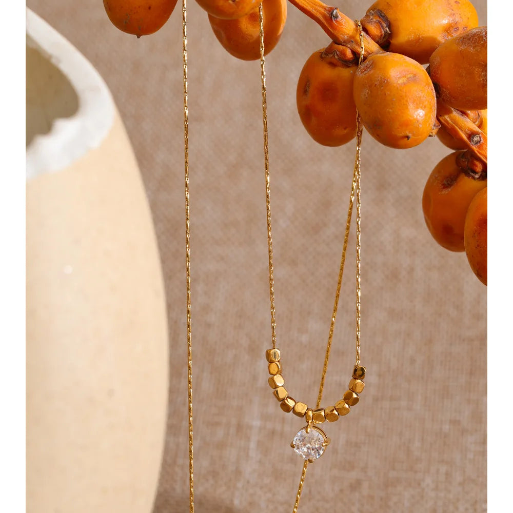 Cubic zirconia beaded geometric necklace in gold-plated stainless steel with cubic zirconia.