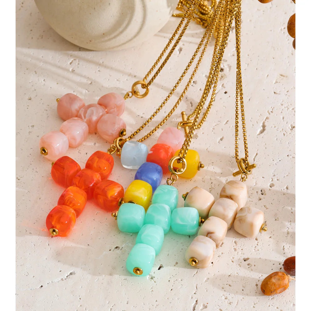 Resin acrylic cross necklace in gold-plated stainless steel with resin and acrylic.