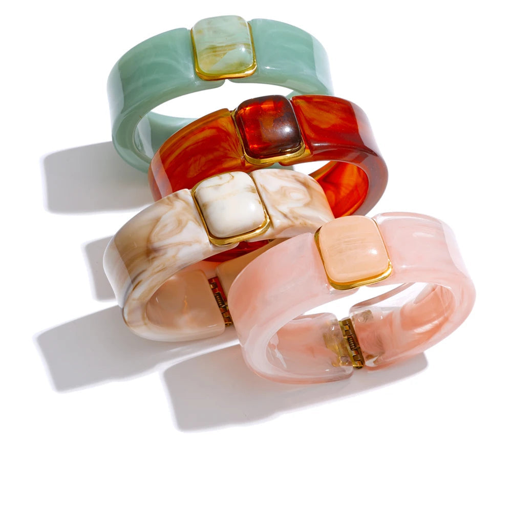 Gold-plated stainless steel bracelet with acrylic stones in shades of pink, white, and green.