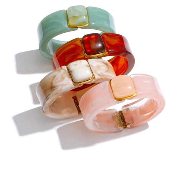 Gold-plated stainless steel bracelet with acrylic stones in shades of pink, white, and green.