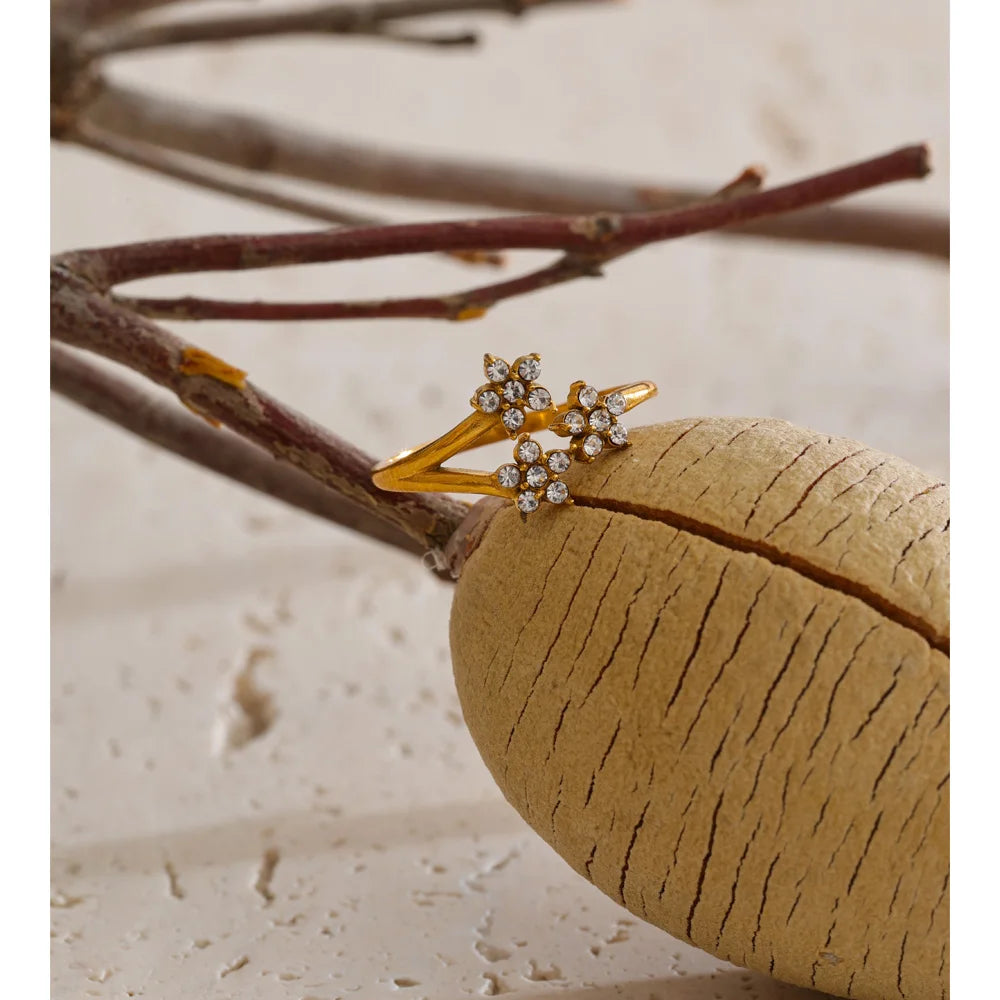 Cubic zirconia flower ring in 18K gold-plated stainless steel with cubic zirconia.