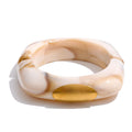 Resin acrylic geometric bracelet in gold-plated stainless steel with resin and acrylic.