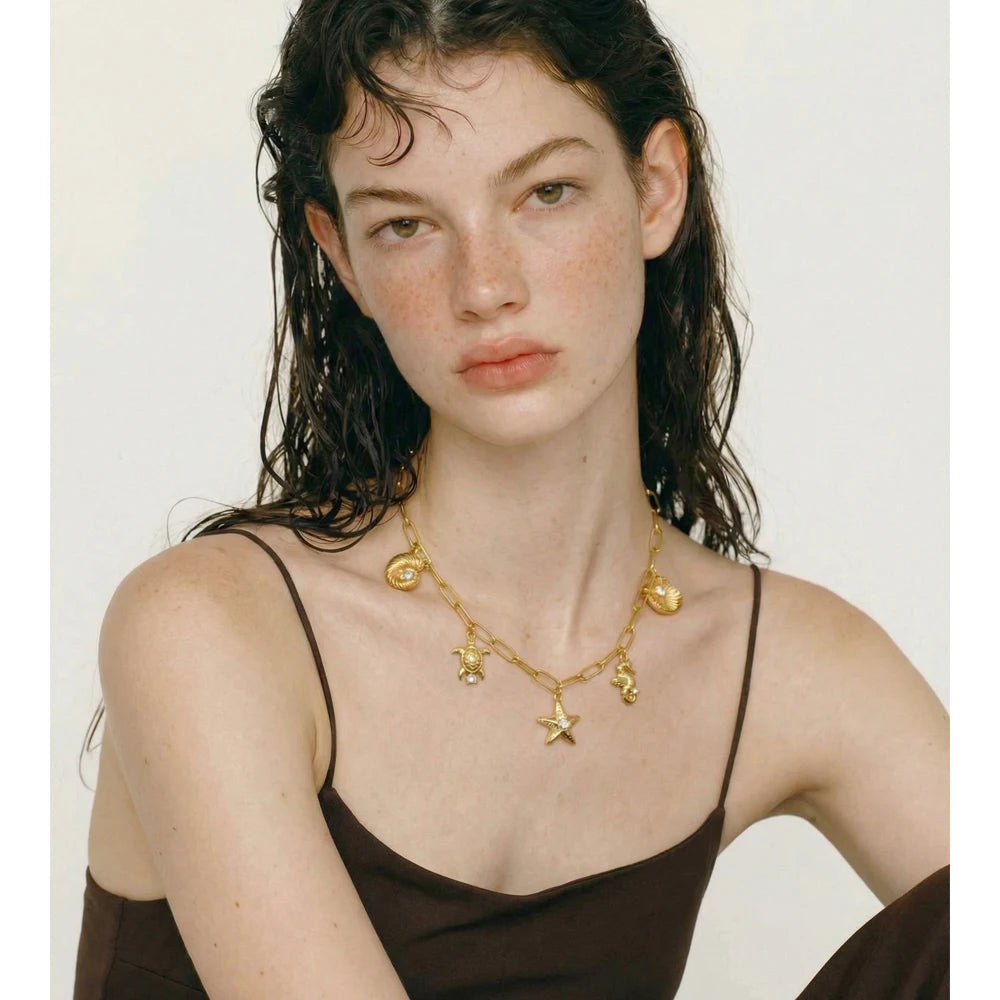 Cubic zirconia shell star necklace in gold-plated stainless steel with cubic zirconia and shell.