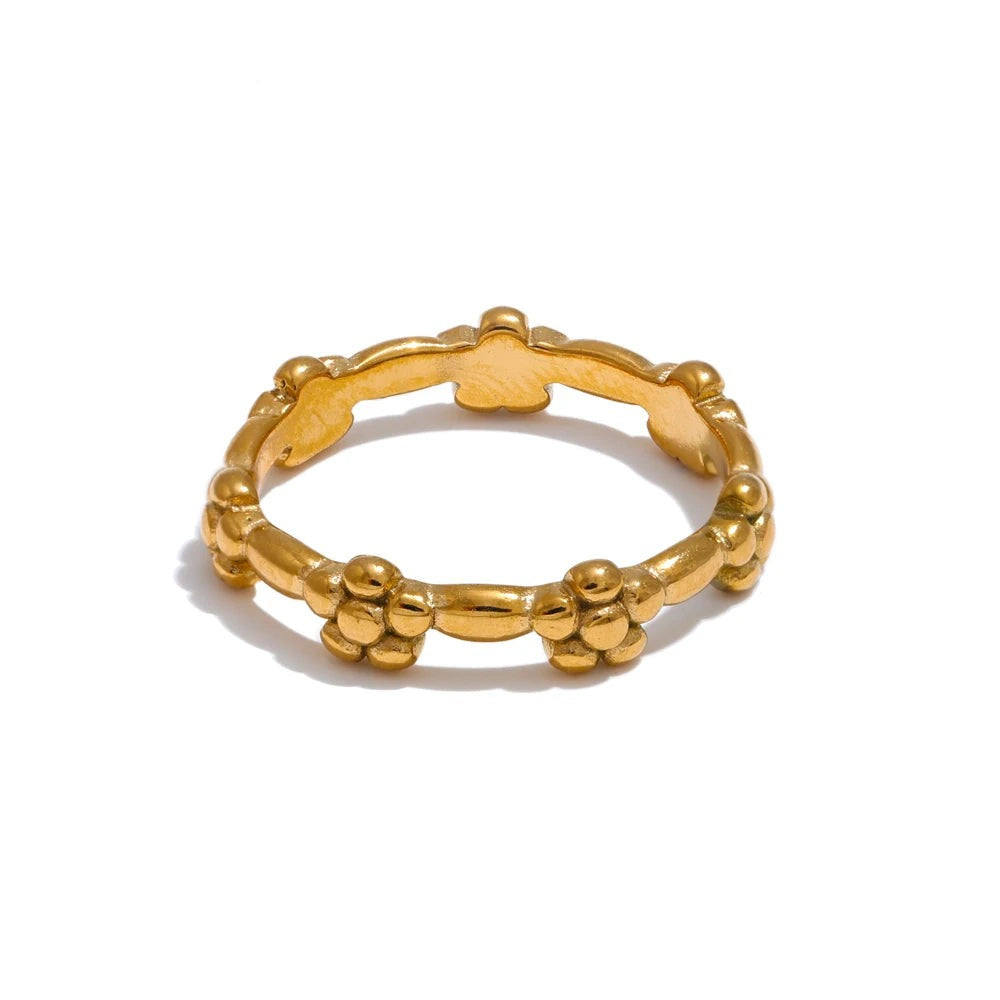 Gold-plated ring with a unique design featuring multiple small balls on the band.