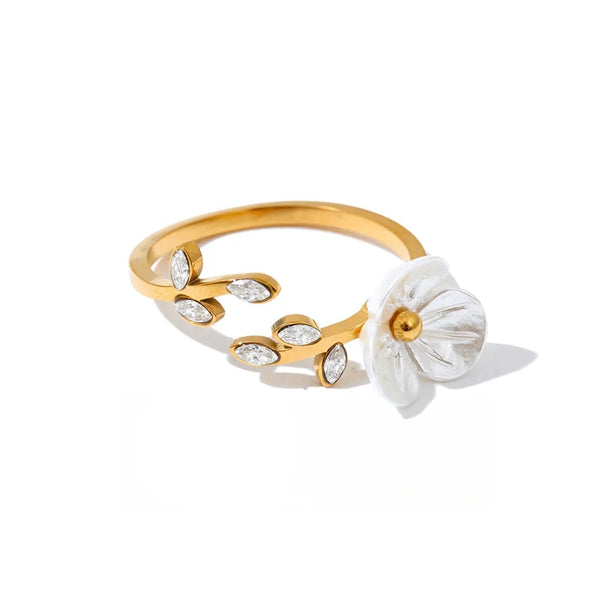 Gold-plated ring with cubic zirconia and resin detailing a flower.