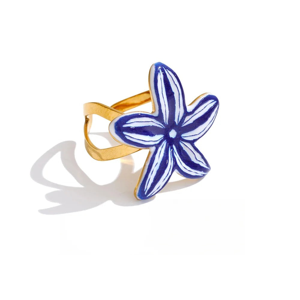 Gold-plated stainless steel ring with blue enamel flower design.