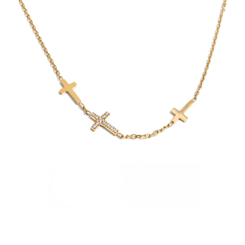 Gold-plated stainless steel necklace with cross pendant and cubic zirconia stones.
